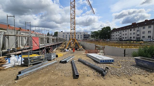 Baufeld mit Kran und Nachbarschaft